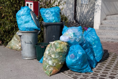 Workers wearing PPE and loading commercial waste into a secure vehicle